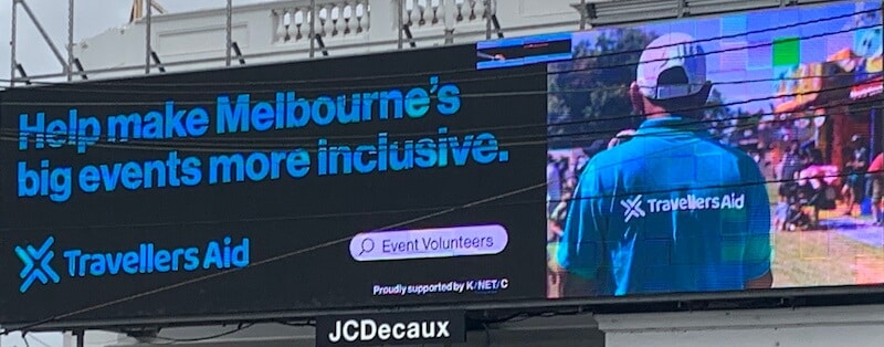 One of the billboards in the campaign. On the right is a picture of a volunteer at an event. Text reads, 'Help make Melbourne's big events more inclusive'. 